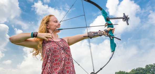 A young girl holding a bow and arrow