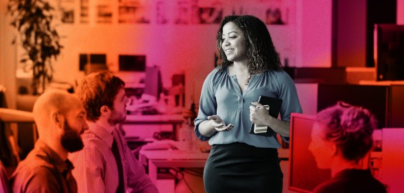 This is a stylised image of a woman speaking to her colleagues at work. Her image is emphasized over a red an orange background