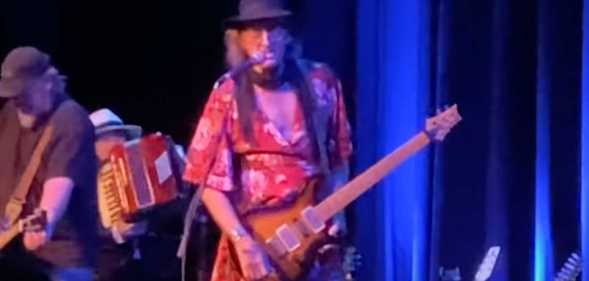 James McMurty performing on stage in a dress