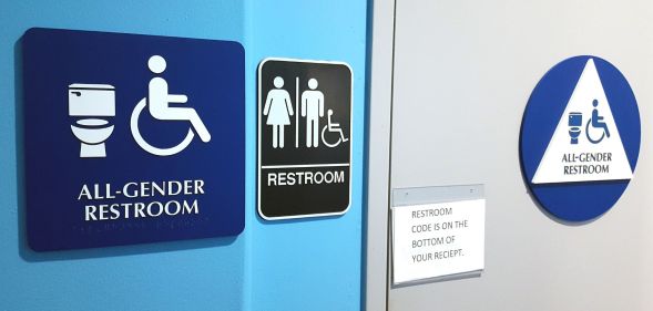 A set of sigjns indicating a gender-neutral bathroom facility.