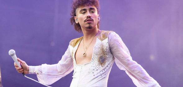 Greta Van Fleet's Josh Kiszka performs on stage, holding a microphone.