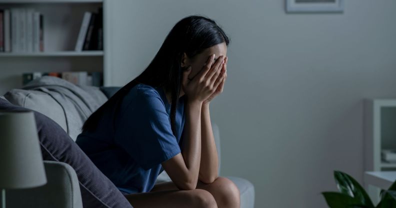 Image of a woman sitting with her head in her hands to illustrate a story about mental health