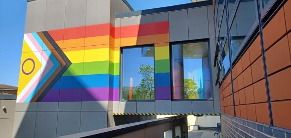 NHS hospital adorned with Progress Pride flag mural