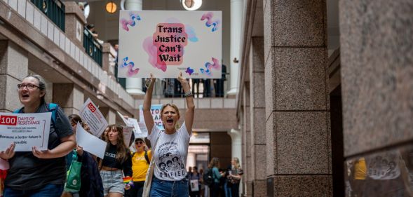 A person holds up a sign reading 'trans justice can't wait' as LGBTQ+ and trans rights advocates protest in the Texas Capitol Building against the wave of anti-LGBTQ+ bills in the state including a gender-affirming healthcare ban for trans youth