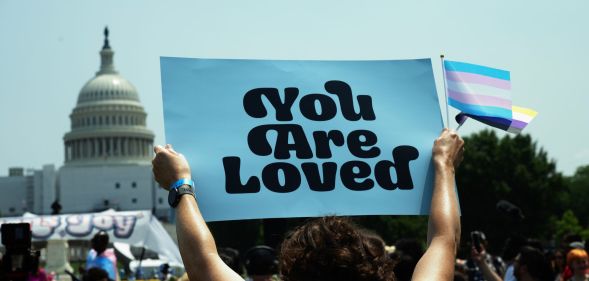 A person holds up a sign reading 'you are loved' during a demonstration in favour of the trans community amid legislative attacks on trans youth being able to access gender-affirming care