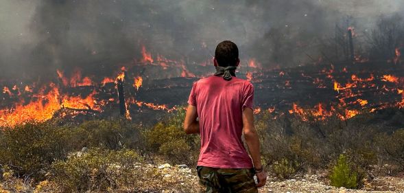 A person stares at the wildfires across Greece.