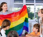 LGBTQ education in action as a teacher shows her class a Pride flag.