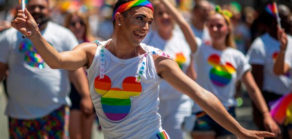 A person dances during a DIsney pride parade.