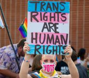 Person holds up a sign reading "trans rights are human rights" at a protest in California