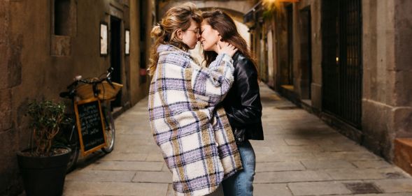 Stock image of two women kisses on an alley street