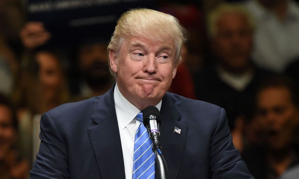 President Donald Trump, who has been taken off the Colorado primary ballot after a ruling by the state's supreme court, wears a suit and tie while speaking at a podium