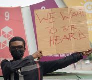 LGBTQ+ activist Prince Frimpong holds up a sign reading 'we want to be heard' while protesting anti-LGBTQ+ sentiment in Ghana