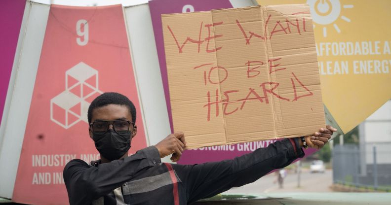 LGBTQ+ activist Prince Frimpong holds up a sign reading 'we want to be heard' while protesting anti-LGBTQ+ sentiment in Ghana