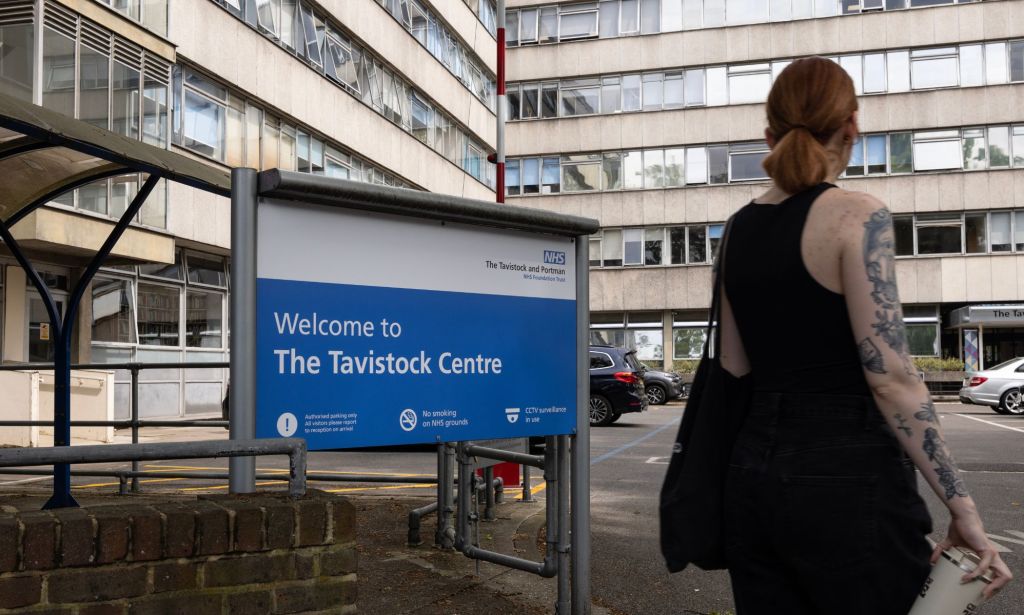 A person walking past the Tavistock Centre sign.