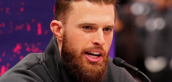 Harrison Butker speaking into a microphone during an NFL press conference.