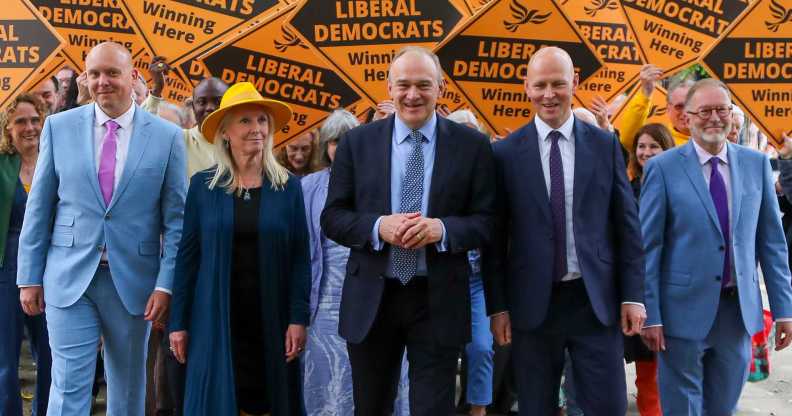 Leader of the Liberal Democrats Ed Davey (C) walks in front of Lib Dem supporters with prospective parliamentary candidates Cameron Thomas, Tewkesbury (L), Roz Savage, South Cotswolds (2L), Max Wilkinson, Cheltenham (2R) and Paul Hodgkinson, North Cotswolds (R) while campaigning ahead of the forthcoming general election on May 23, 2024 in Cheltenham, England.