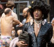 Marsha P Johnson photographed walking through a busy street.