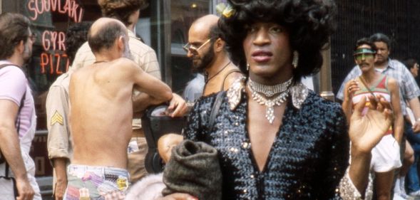 Marsha P Johnson photographed walking through a busy street.