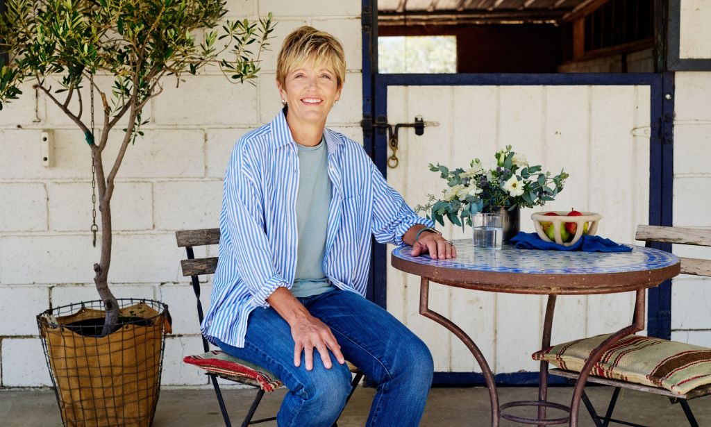 This is an image of a woman sitting at a table outside.
