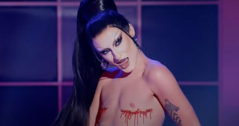 Drag Race star Gottmik with glitter covering her top surgery scars during a lip-sync.