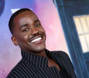 Ncuti Gatwa smiling in a black pinstriped suit at the Doctor Who premiere