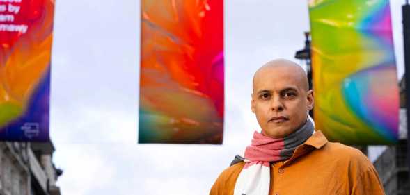 Adham Faramawy stands in front of his reimagined Pride flags