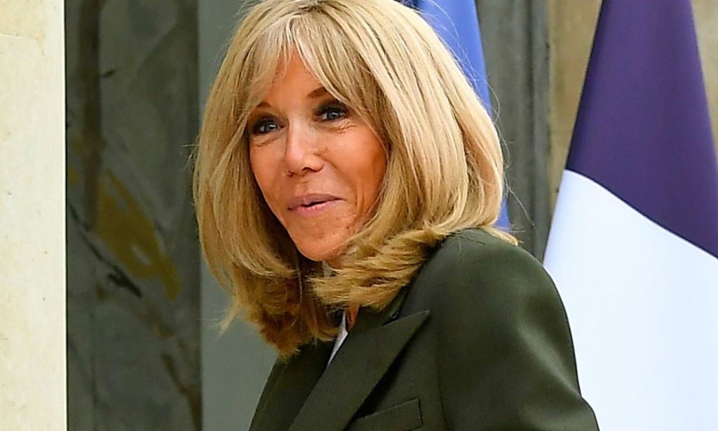 Brigitte Macron walking in a government building.