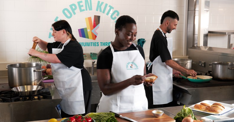 This is an image of three people preparing food in a kitchen