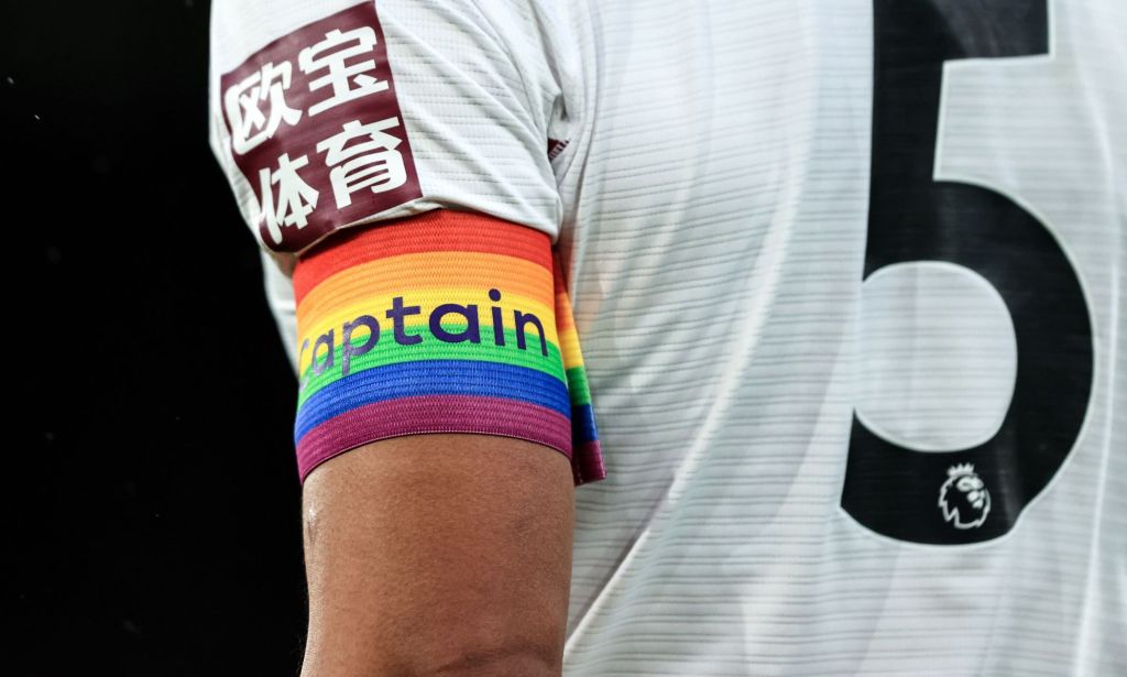 A football player wearing an LGBTQ+ armband.