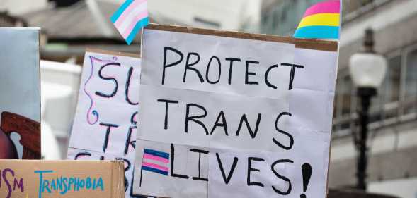 a placard reading protect trans lives