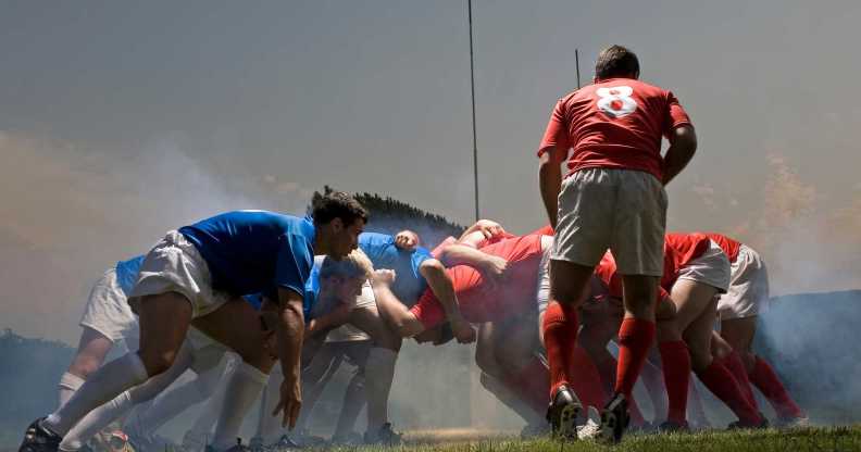 Rugby players in scrum on pitch, ground view