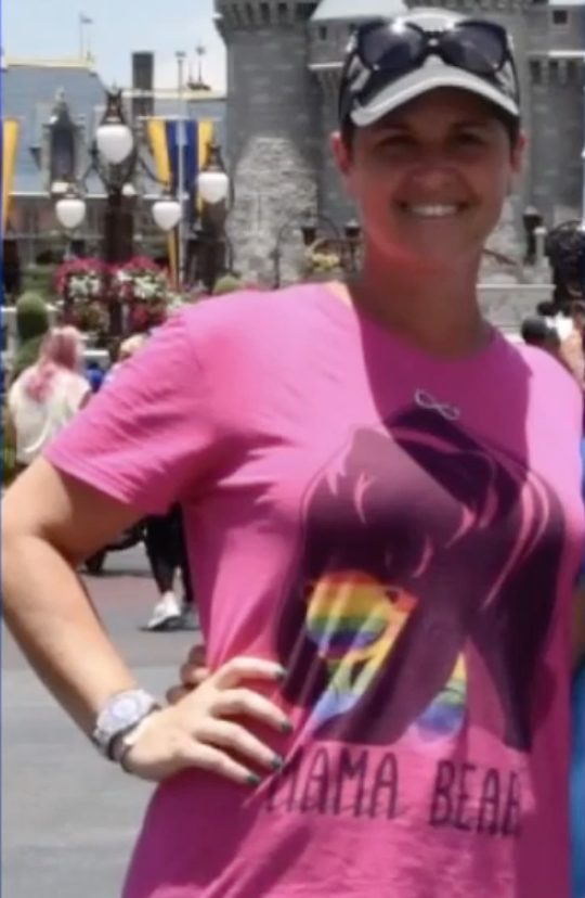 Jessica Norton at Disney World wearing a rainbow-themed pink "Mama Bear" t-shirt