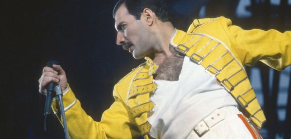 Freddie Mercury performing in his signature yelow jacket and white t-shirt.