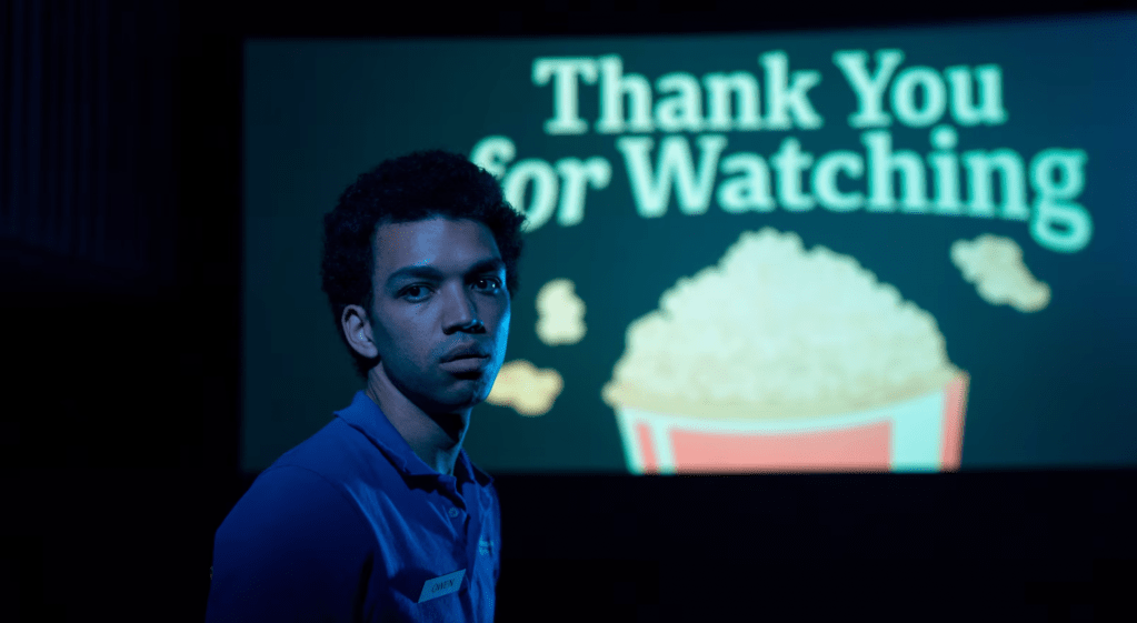 A still from I Saw The TV Glow featuring Owen looking away from a screen that reads "Thank you for watching"