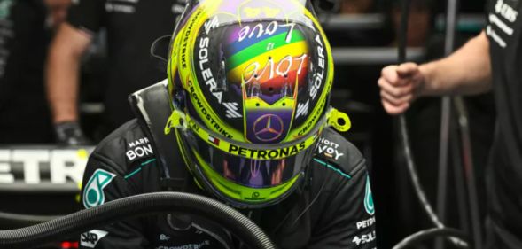 Lewis Hamilton wearing a helmet with a rainbow flag and Love is Love