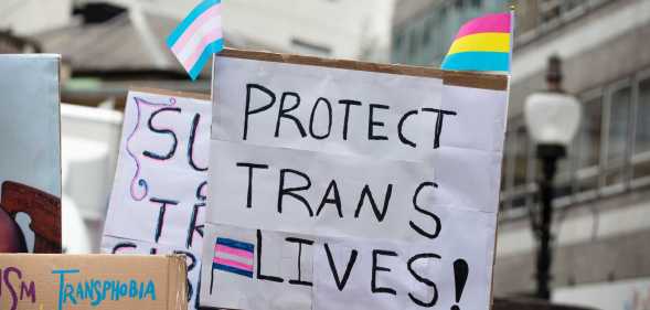 a sign reading 'protect trans lives'