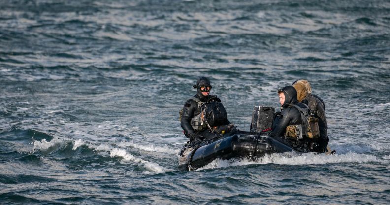 3 navy seals sitting in a boat