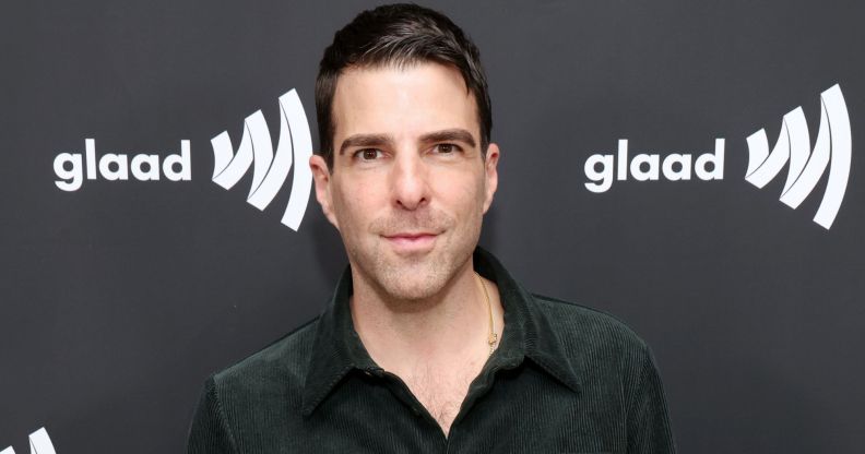 Zachary Quinto poses in a dark green shirt while on the GLAAD media award red carpet.