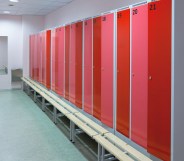 A changing room with a row of red lockers