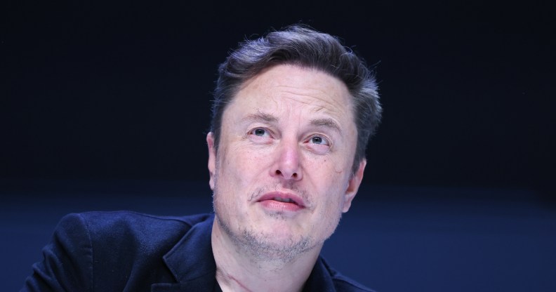 Elon Musk wearing a suit at a panel