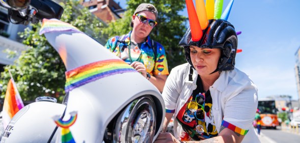 A person operating a Pride themed Harley-Davidson