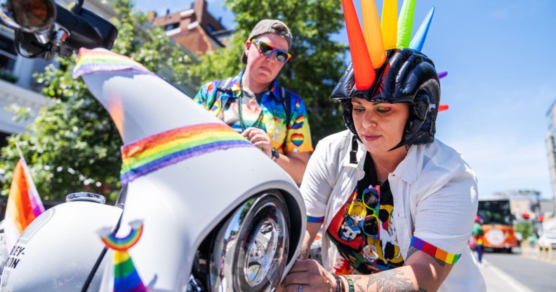 A person operating a Pride themed Harley-Davidson