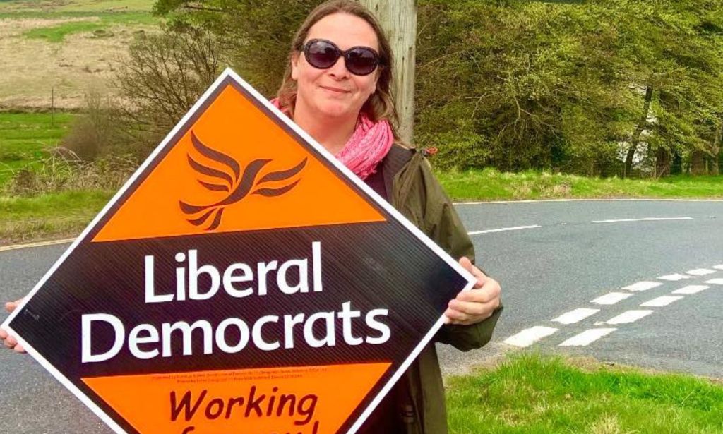 Holly Greenberry-Pullen holding a Liberal Democrats sign.