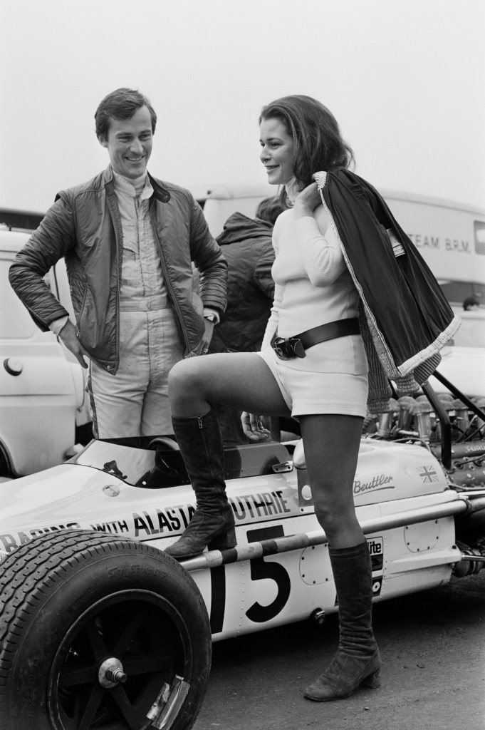 Mike Beuttler standing next to the car with his friend Anne Ries whose leg is resting against the car.