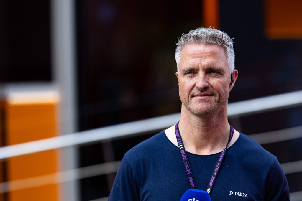 Ralf Schumacher in a blue t shirt with a mic ready to commentate