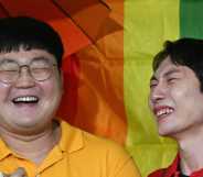 South Korean same-sex couple So Seong-wook (L) and Kim Yong-min (R) react as they speak to reporters outside the Supreme Court building in Seoul on July 18, 2024 after the court's ruling on a lawsuit against the National Health Insurance Service for their dependent family status.