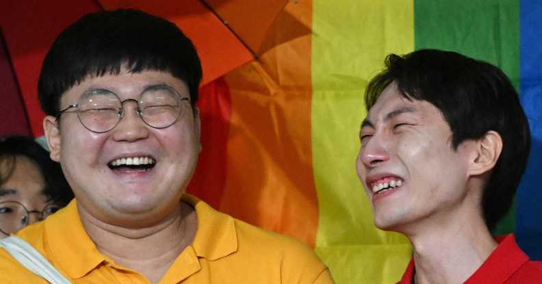 South Korean same-sex couple So Seong-wook (L) and Kim Yong-min (R) react as they speak to reporters outside the Supreme Court building in Seoul on July 18, 2024 after the court's ruling on a lawsuit against the National Health Insurance Service for their dependent family status.