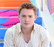 Kit Connor poses in a white shirt at San Diego Comic Con.