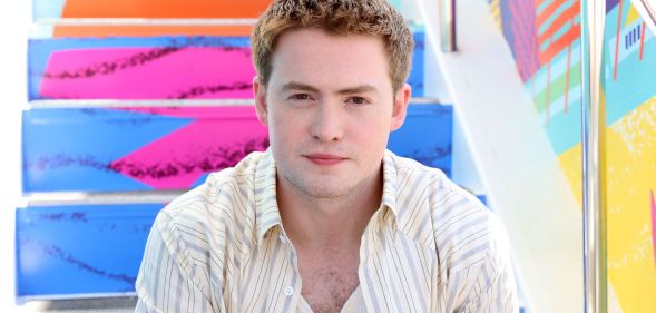 Kit Connor poses in a white shirt at San Diego Comic Con.