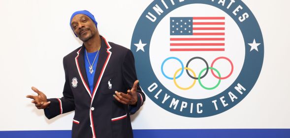 Snoop Dogg standing in front of a sign that says 'United States Olympic Team'